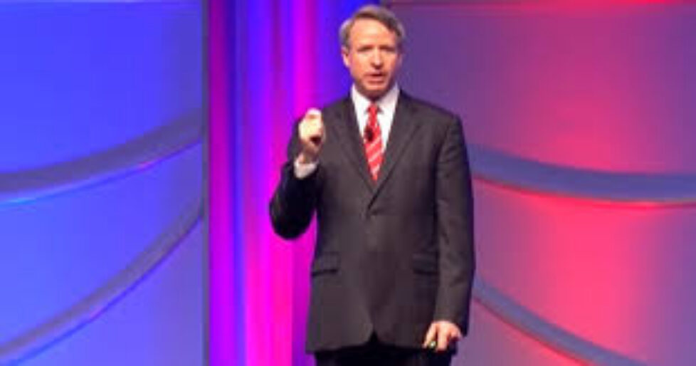 A man in a suit and tie holding a pen.