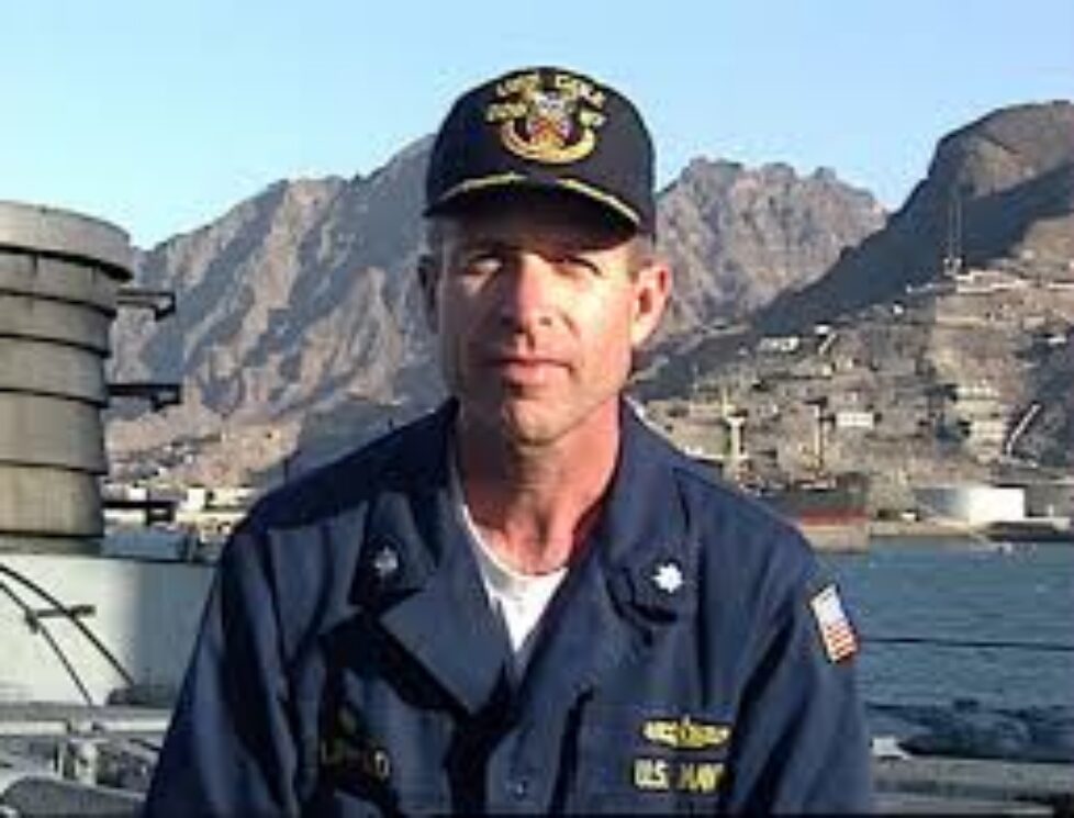 Sailor posing on a ship deck with mountains